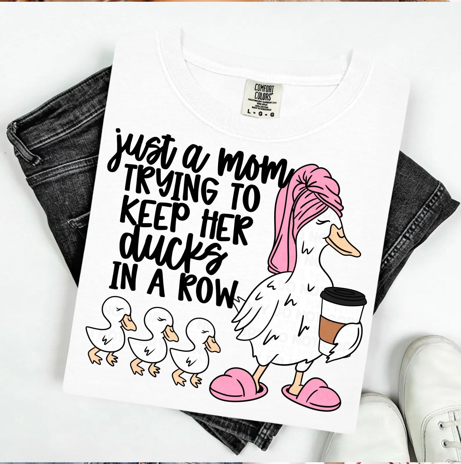 Gray graphic tee with "Just a Mom Trying to Keep Her Ducks in a Row" slogan, casual style, from Anchored Grace Boutique.