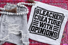 Bleacher Creature with Opinions graphic tee by Anchored Grace Boutique, featuring colorful cartoon character design on a casual shirt.