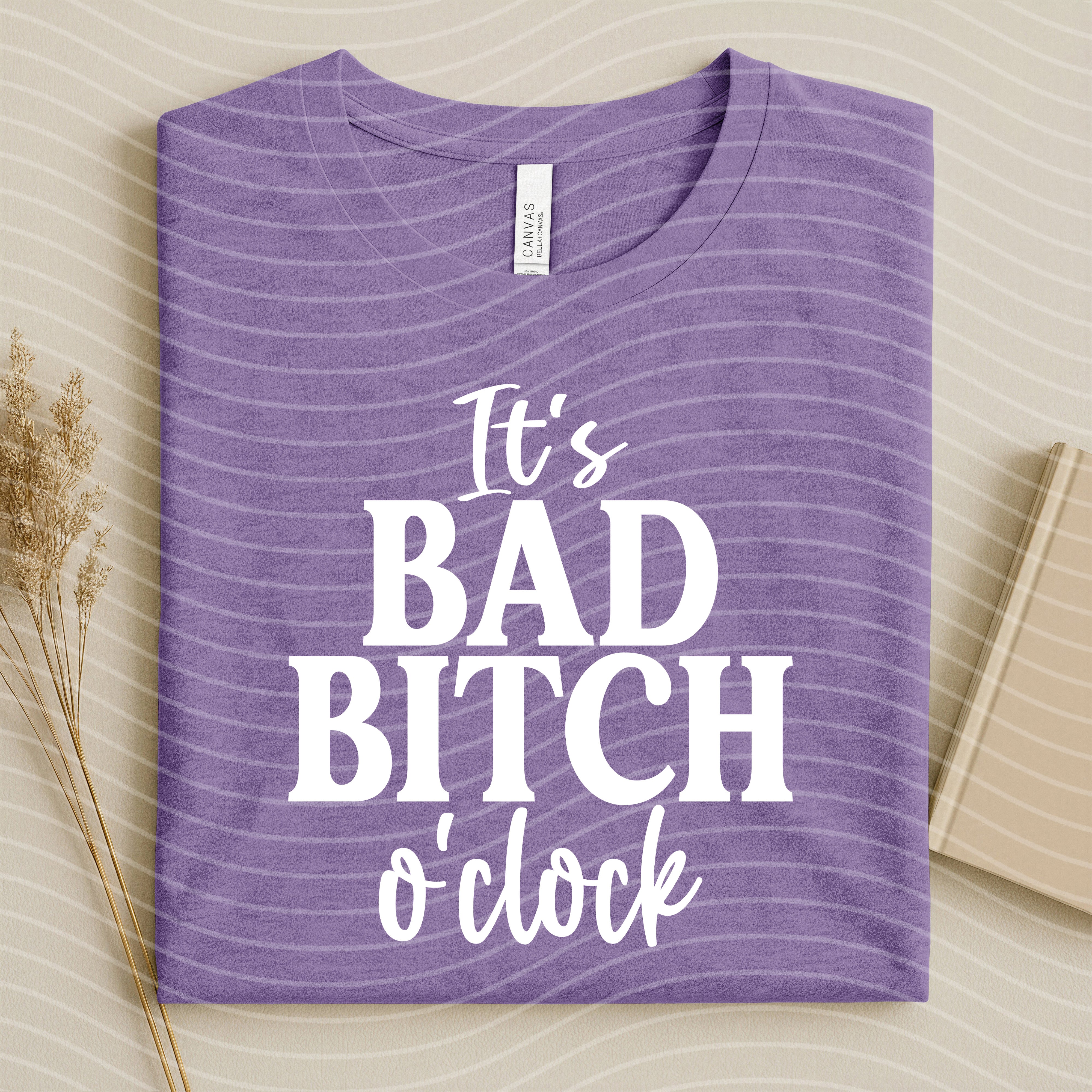 Black graphic tee from Anchored Grace Boutique featuring bold "It's Bad B**** O'Clock" print on the front.