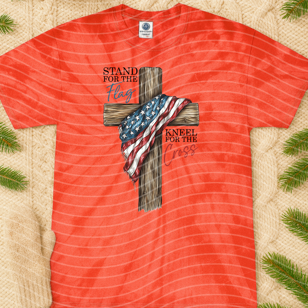 Graphic tee featuring a flag and cross design from Anchored Grace Boutique, with kneeling figure and inspirational religious imagery.