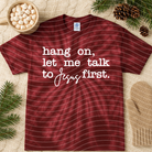 Graphic tee featuring text "Hang on Let Me Talk to Jesus First" from Anchored Grace Boutique, casual style, front view.
