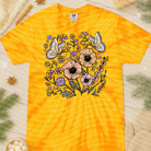 Spring floral graphic tee from Anchored Grace Boutique featuring colorful flower designs and casual fit.