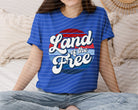 Black Land of the Free graphic tee by Anchored Grace Boutique featuring patriotic design and bold lettering.