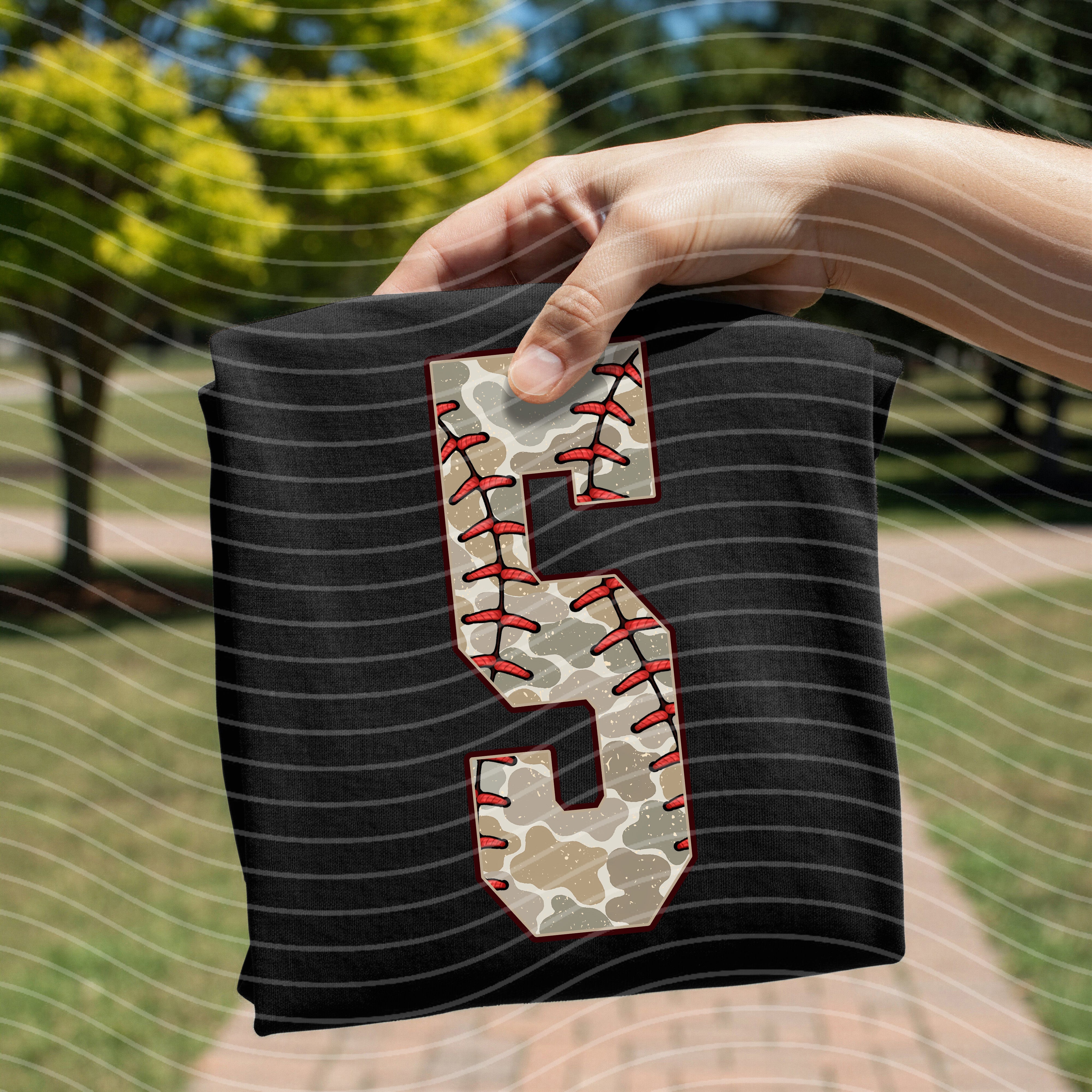 Camo baseball graphic tee with bold numbers from Anchored Grace Boutique, casual streetwear style for men or women.