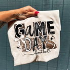 Anchored Grace Boutique Game Day football graphic tee featuring a bold football design on a casual t-shirt.