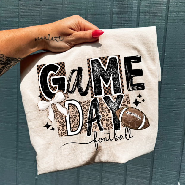Anchored Grace Boutique Game Day football graphic tee featuring a bold football design on a casual t-shirt.