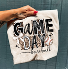 Gray Game Day Baseball Graphic Tee from Anchored Grace Boutique featuring a baseball graphic design on soft cotton fabric.