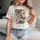 Kepp Flying graphic tee from Anchored Grace Boutique featuring a colorful flying bird design on soft cotton fabric.