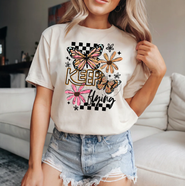 Kepp Flying graphic tee from Anchored Grace Boutique featuring a colorful flying bird design on soft cotton fabric.