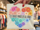 Celebrate Minds of All Kinds graphic tee by Anchored Grace Boutique, featuring a colorful, artistic design on a casual t-shirt.