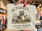 Actually I am the Problem graphic tee by Anchored Grace Boutique, shown in black with white text on a casual t-shirt.