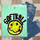 Softball-themed graphic tee by Anchored Grace Boutique featuring a cheerful happy face design, perfect for casual wear.