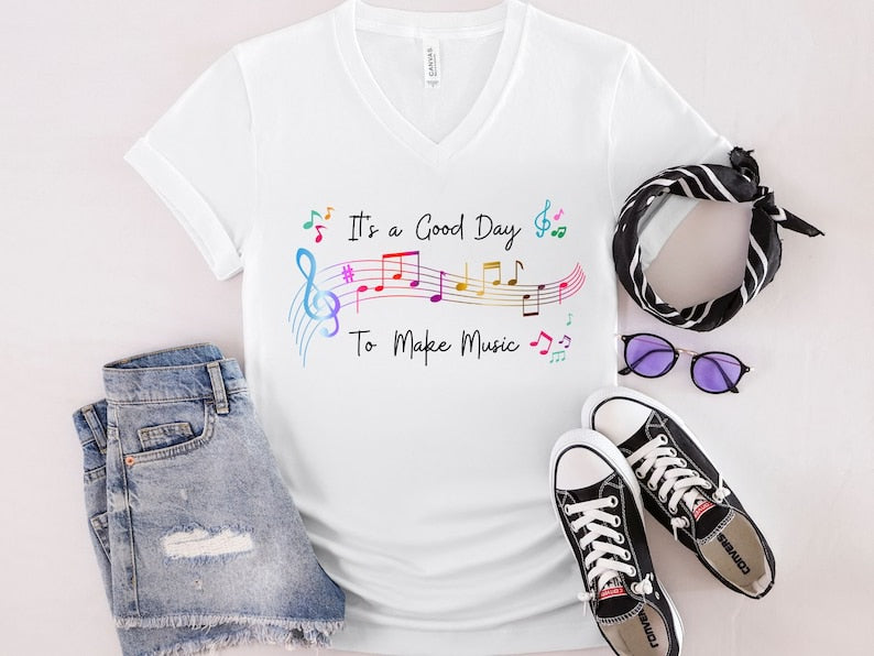 It's a graphic tee from Anchored Grace Boutique with a "It's a Good Day to Make Music" design in vibrant colors.