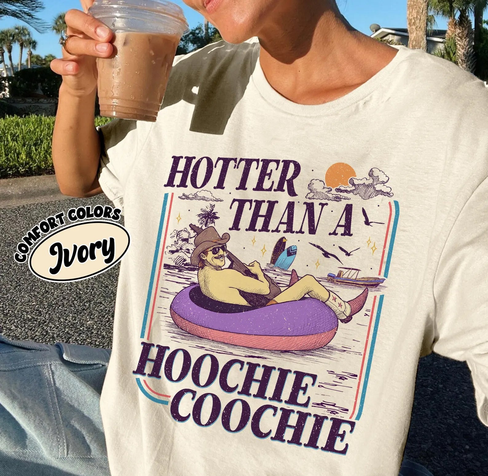 Black graphic tee from Anchored Grace Boutique featuring bold "Hotter Than a Hoochie Coochie" text in vibrant colors.