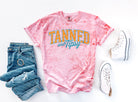 Tanned and Tipsy graphic tee by Anchored Grace Boutique featuring a casual, stylish design on a comfortable cotton shirt.