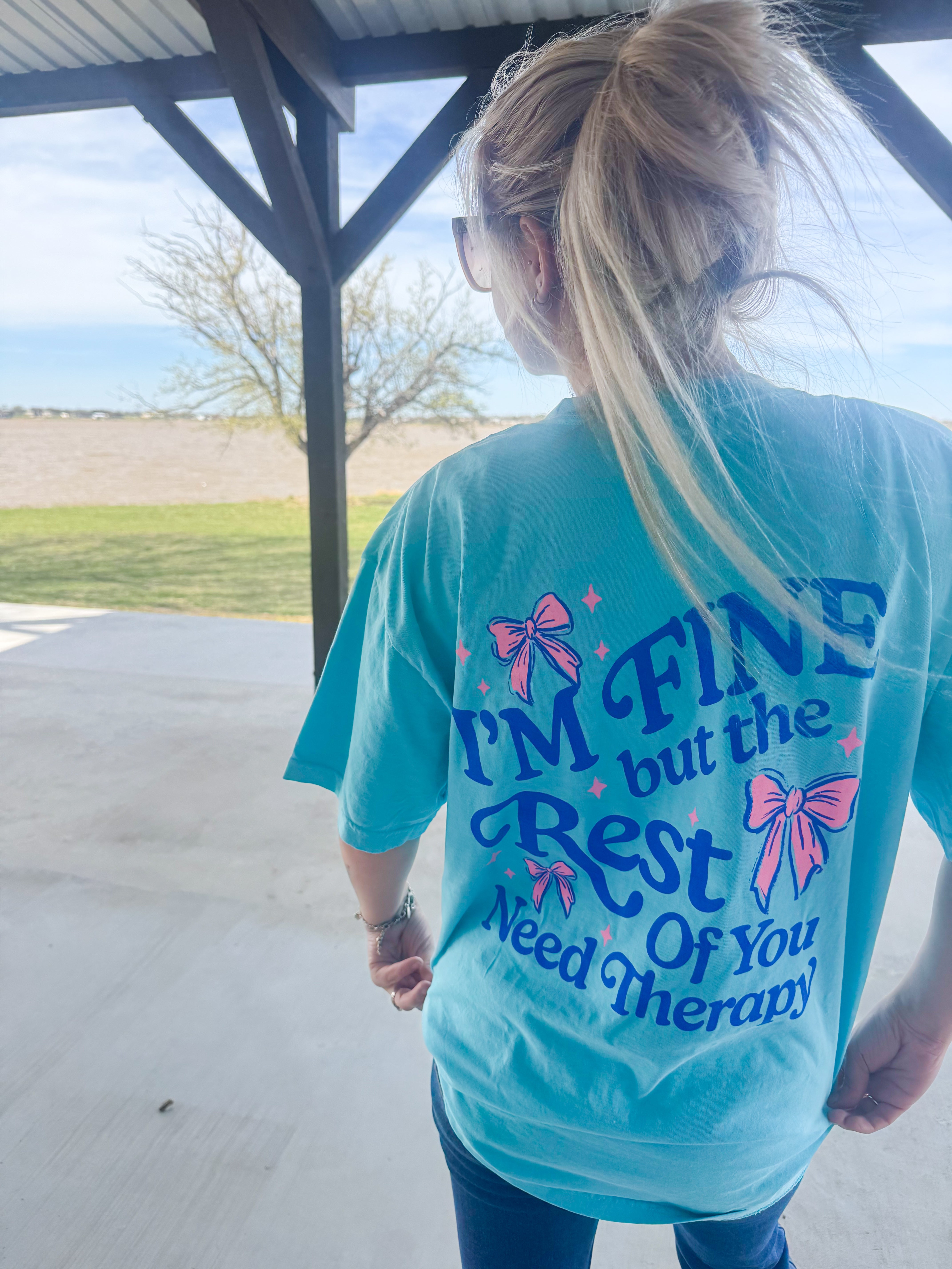 Black cotton T-shirt from Shop Karma Tees with "I’m Fine, But Yall Need Therapy" printed in bold text.