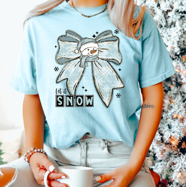 Let It Snow graphic tee by Anchored Grace Boutique featuring festive winter snowflake and holiday-themed design on soft cotton fabric.