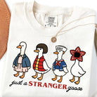 Black graphic tee featuring a "Just a Stranger" goose design from Anchored Grace Boutique, casual unisex t-shirt.