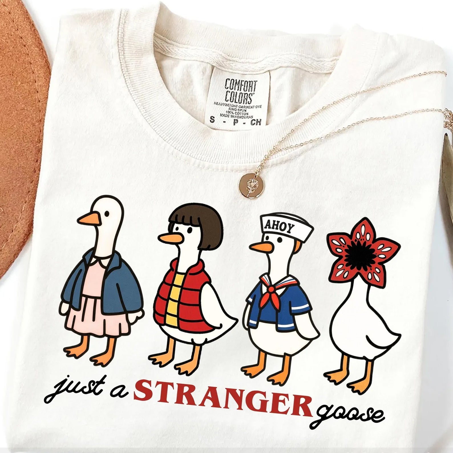 Black graphic tee featuring a "Just a Stranger" goose design from Anchored Grace Boutique, casual unisex t-shirt.