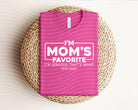Gray graphic tee from Anchored Grace Boutique with "I'm Mom's Favorite" print, casual and comfortable for everyday wear.