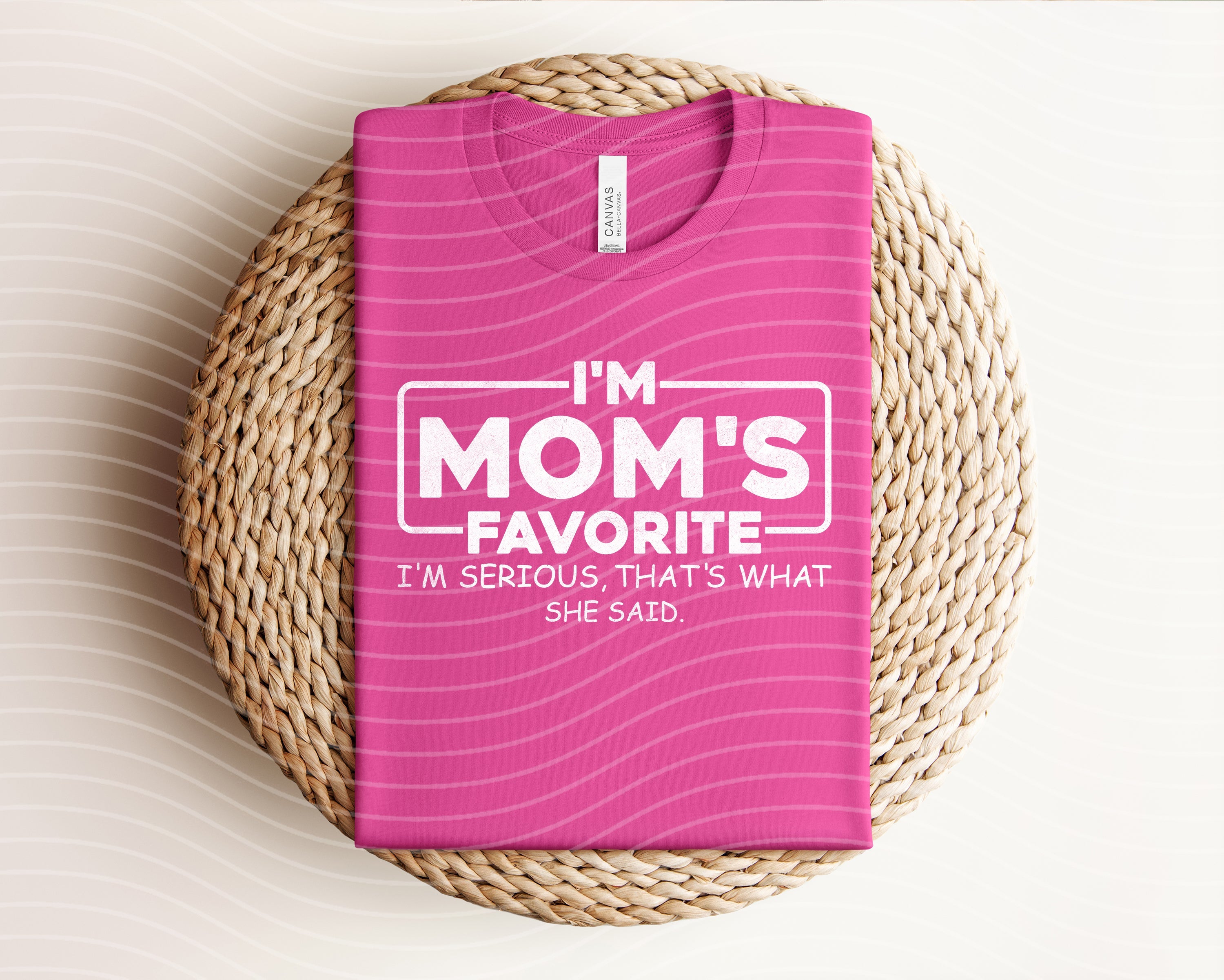 Gray graphic tee from Anchored Grace Boutique with "I'm Mom's Favorite" print, casual and comfortable for everyday wear.