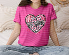 Be Mine graphic tee by Anchored Grace Boutique featuring a stylish design, casual fit, and soft fabric on a white background.