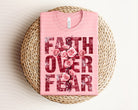 Faith Over Fear graphic tee by Anchored Grace Boutique, showing a stylish black t-shirt with inspirational text design.