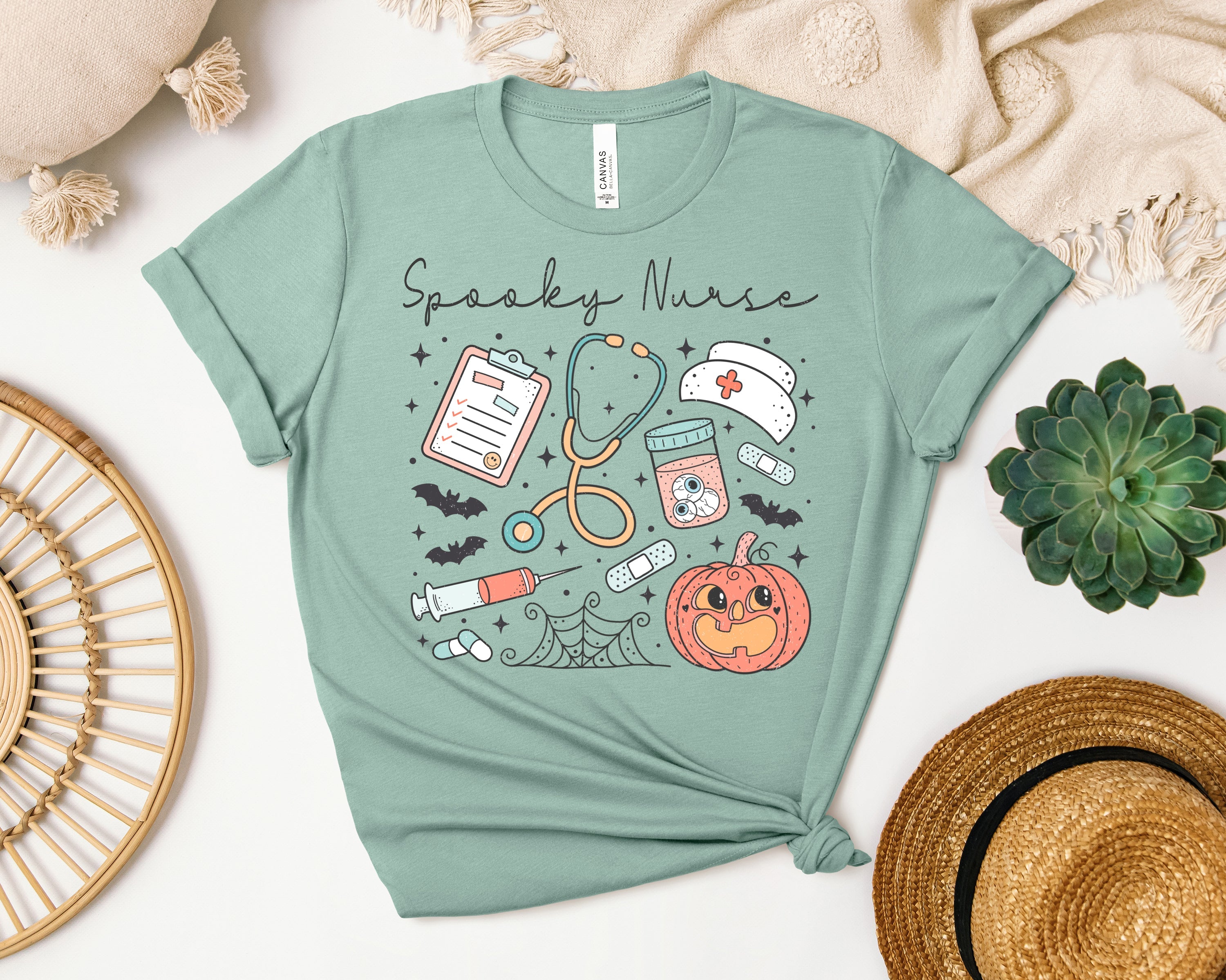 Spooky Nurse graphic tee by Anchored Grace Boutique featuring a Halloween-themed nurse illustration on black cotton fabric.