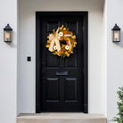 Rustic fall wreath with white pumpkins, golden eucalyptus, wheat, and bow, perfect for front door decor in autumn.