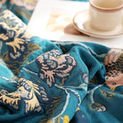 CozyNest Decor boho muslin twin-size cotton blanket with floral teal design, soft and breathable for sofa or bed use.