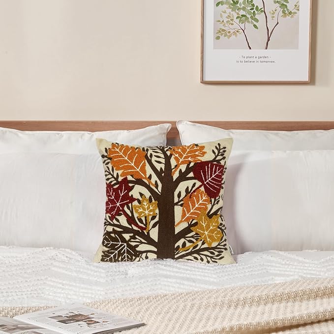 A cozy orange 18x18 inch embroidered throw pillow cover with maple leaf pattern, cotton canvas, for sofa or bed decor.