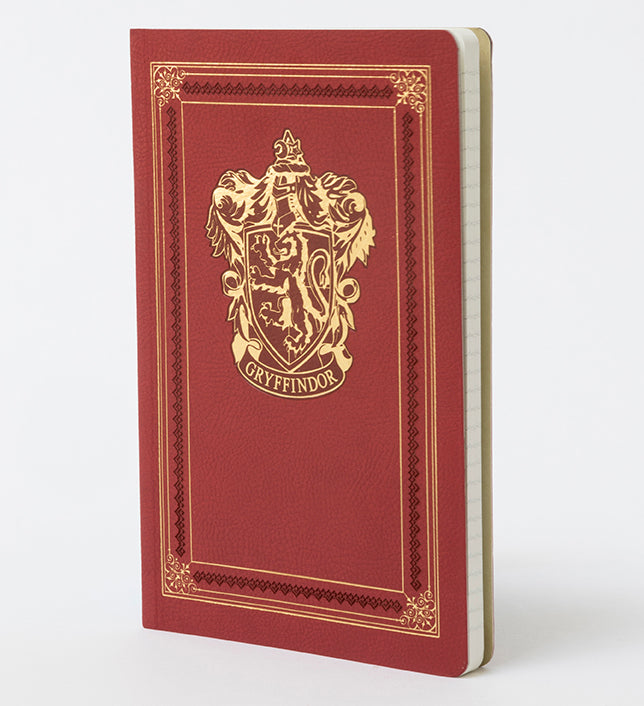 Interior page of Harry Potter Gryffindor ruled softcover notebook by Insight Editions, featuring lined pages with Gryffindor crest design.