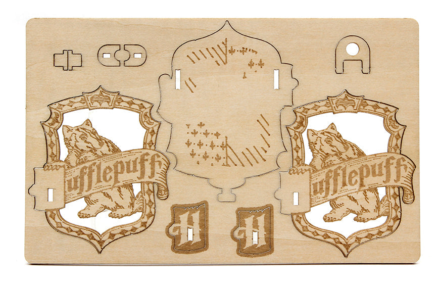 Interior view of the IncrediBuilds Harry Potter Hufflepuff Emblematics kit, featuring stationery and gift items with Hufflepuff emblem details.