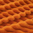 CozyNest Decor fall harvest faux fur throw blanket in burnt orange, plush striped design on a sofa for cozy home decor.