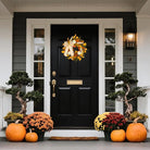 Rustic fall wreath by CozyNest Decor featuring white pumpkins, golden eucalyptus, wheat, and a bow for front door decor.