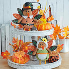 Two plush stuffed turkey figurines with dangling legs, CozyNest Decor Thanksgiving harvest tabletop decorations for fall and autumn decor.