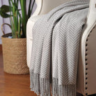 CozyNest Decor Cuddle Dreams silk throw blanket in herringbone gray with hand-knotted fringe, soft, breathable, and natural fabric.