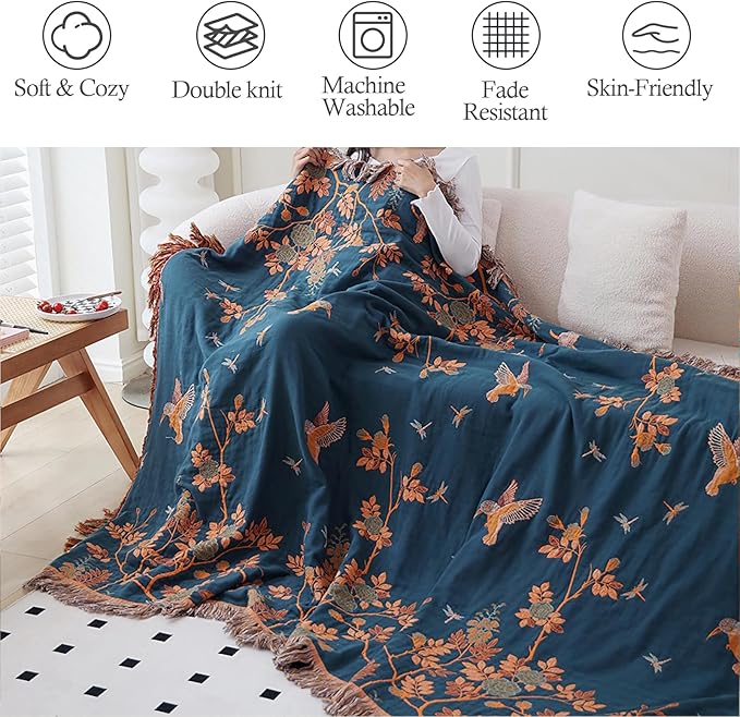 CozyNest Decor boho throw blanket in orange with floral bird pattern, made of 100% organic cotton muslin for bed or sofa decor.
