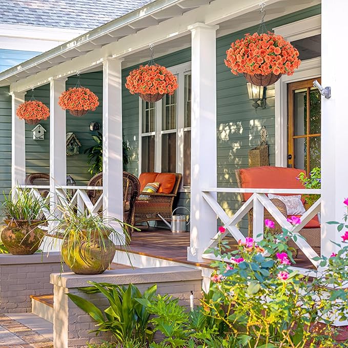 Artificial fall flowers in a hanging basket, featuring orange silk morning glories and eucalyptus for outdoor porch or patio decor.
