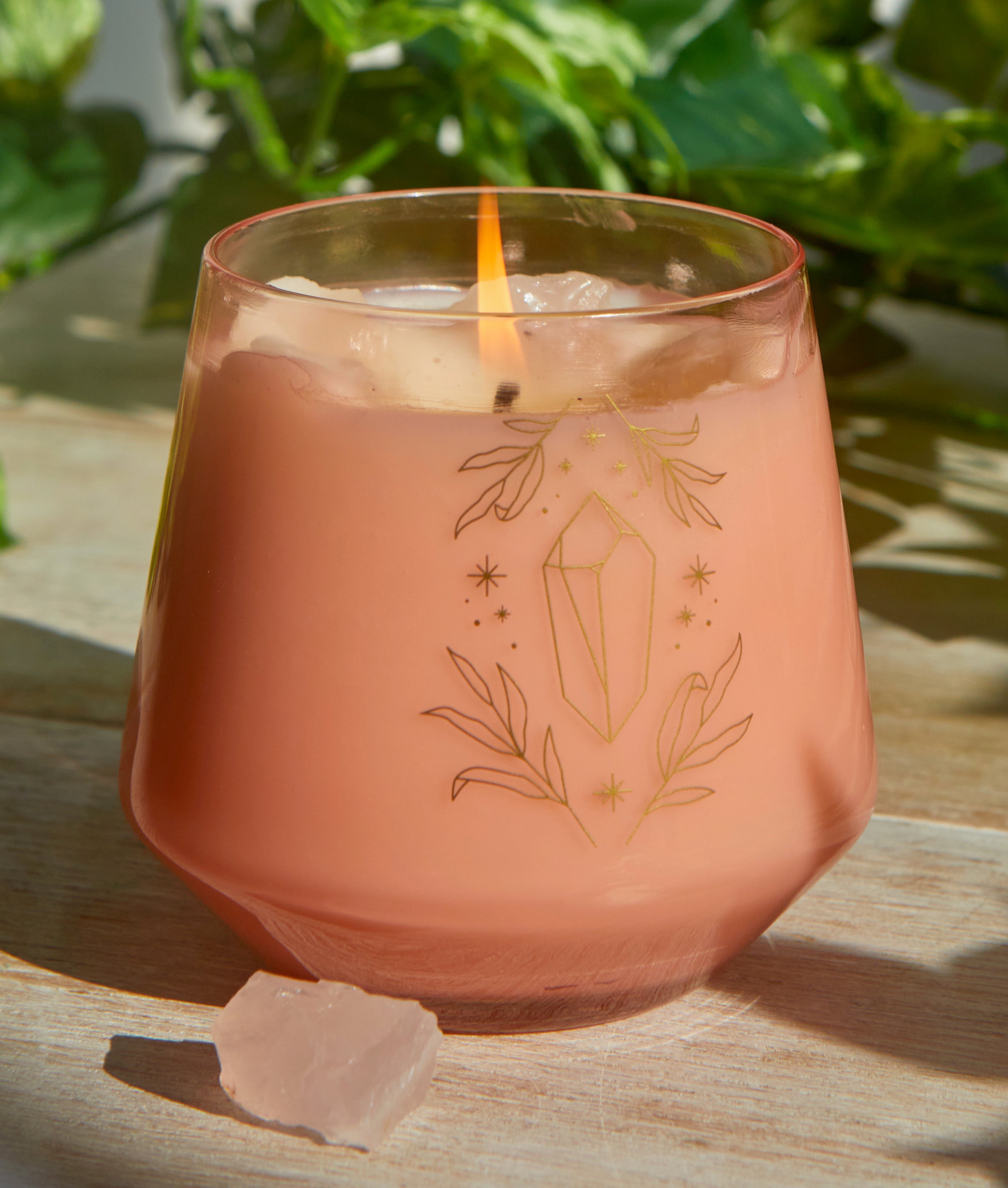 Rose quartz crystal healing scented glass candle on a decorative home decor surface, featuring a clear glass container and soft lighting.