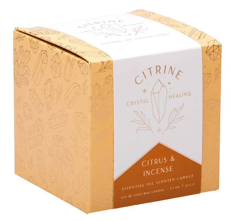 Citrine crystal healing scented glass candle on a wooden surface with decorative elements in a cozy home setting.