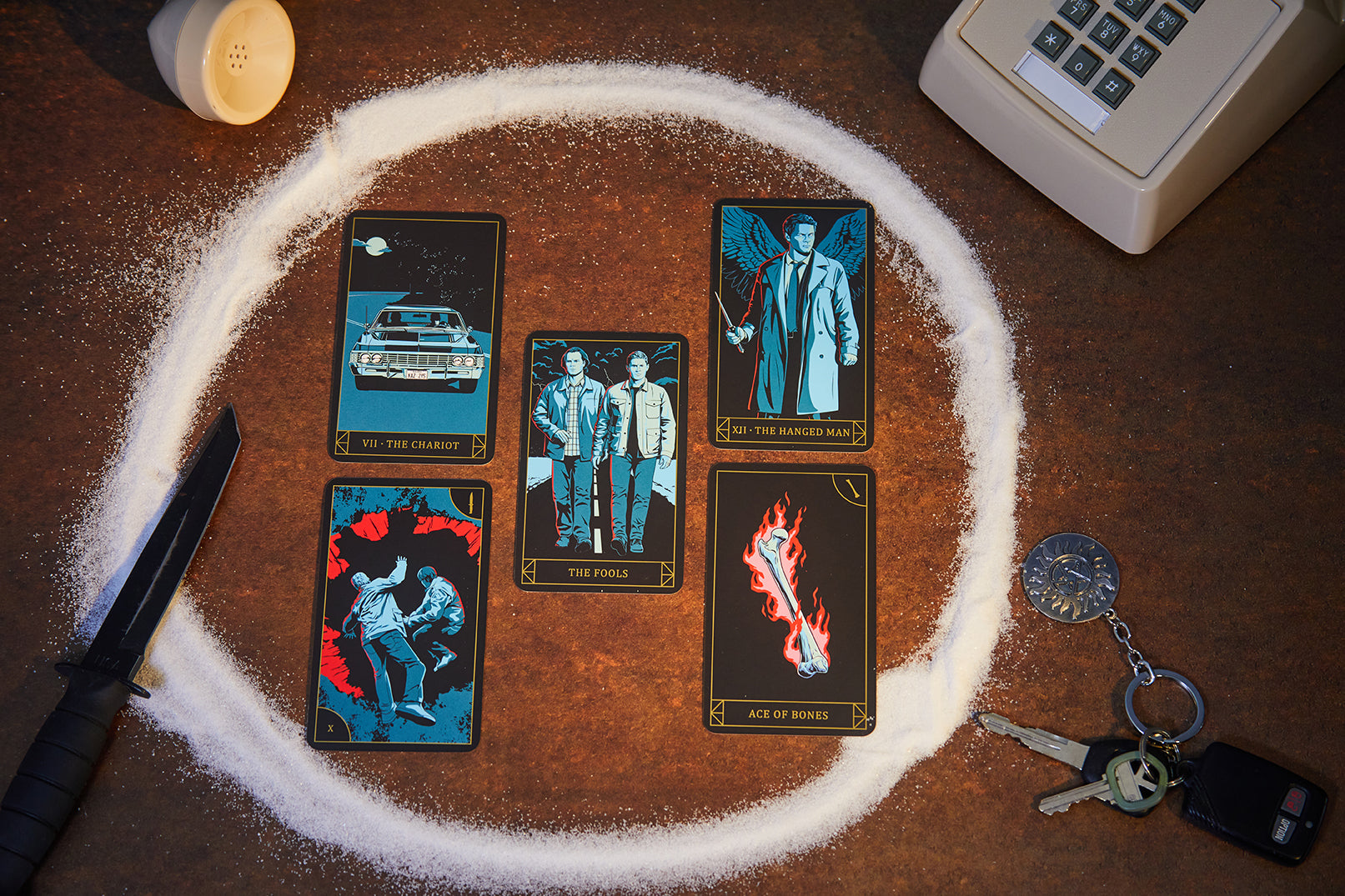 Insight Editions supernatural candle and tarot card deck bundle with candles, tarot cards, and mystical packaging on a wooden surface.