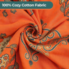 CozyNest Decor fall floral printed cotton throw blanket on a bed, lightweight rustic quilt in orange with a floral pattern.