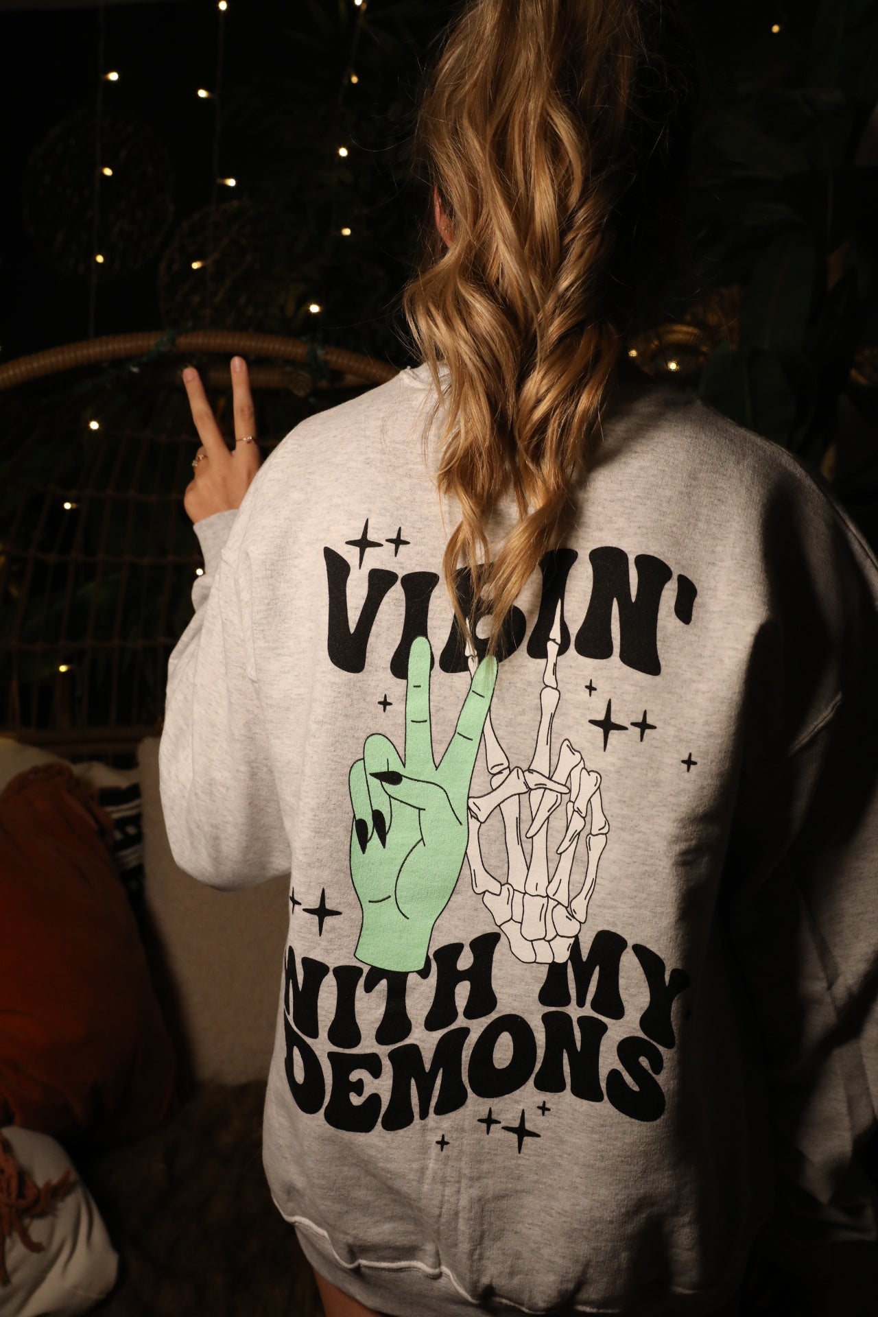 Vibin' with My Demons graphic sweatshirt by Shop Karma Tees featuring dark-themed demon illustrations and bold text design.