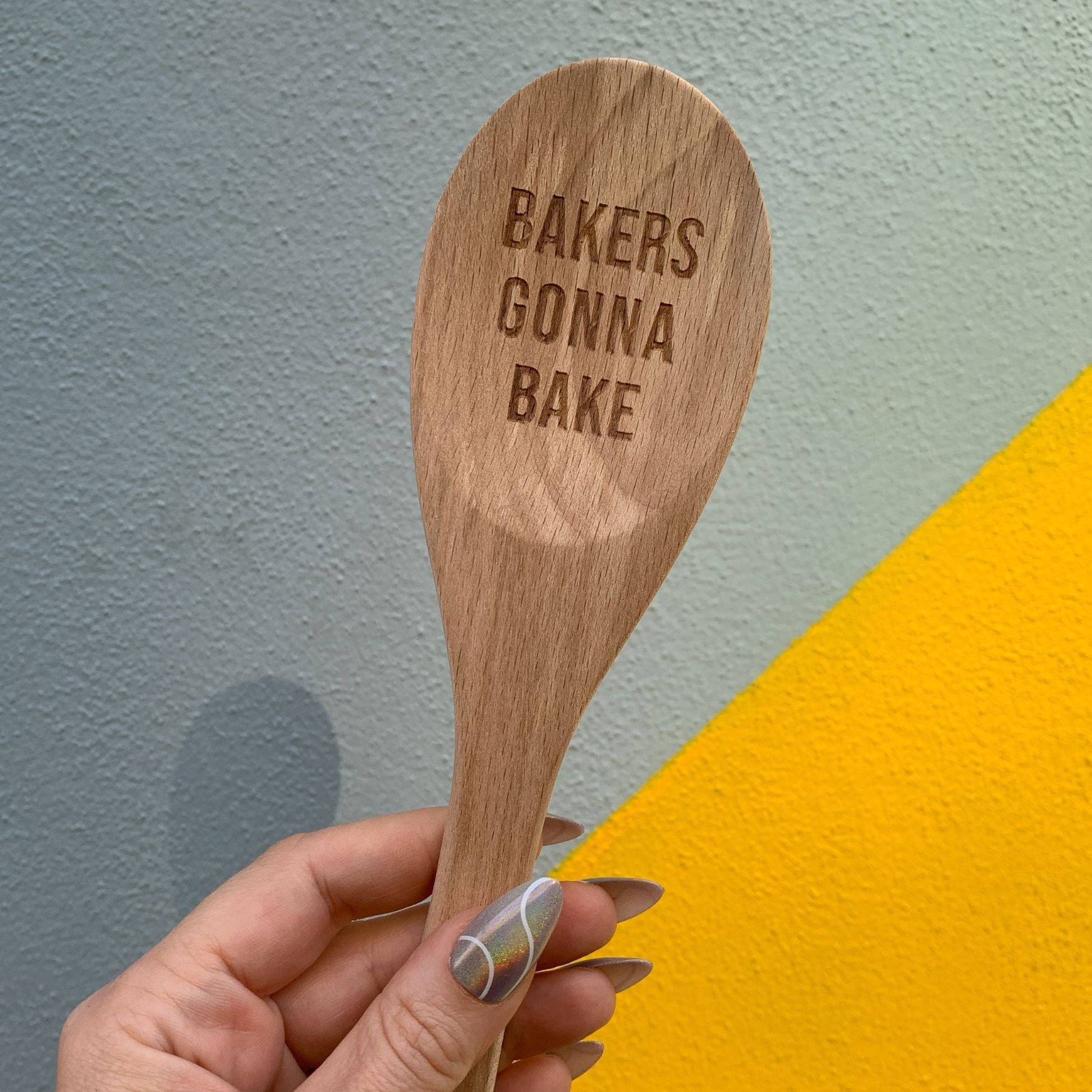 Wooden baking spoon from The Bullish Store in a canvas gift bag, ideal for kitchen cooking and baking tasks.