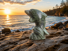 Moss agate dolphin gemstone figurine with intricate patterns, showcasing natural green and brown stone details.