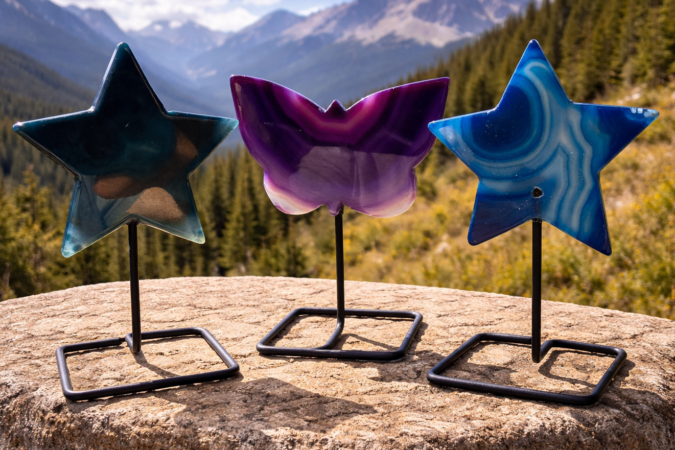 Dyed agate stars and butterfly shapes displayed on stands, showcasing vibrant colors and polished stone textures.