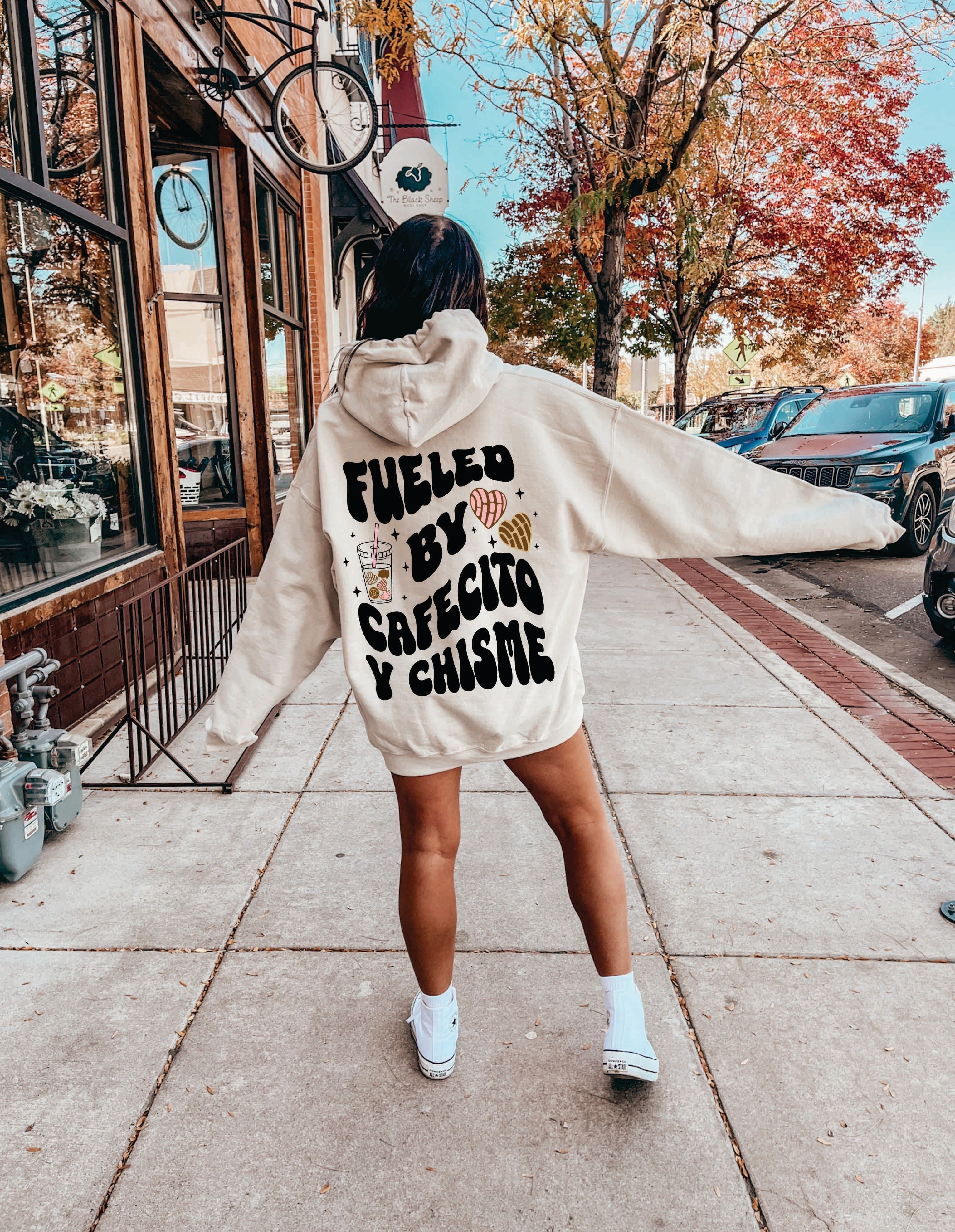 Black Cafecito y Chisme hoodie from Shop Karma Tees featuring a cozy, casual design with printed text on the front.