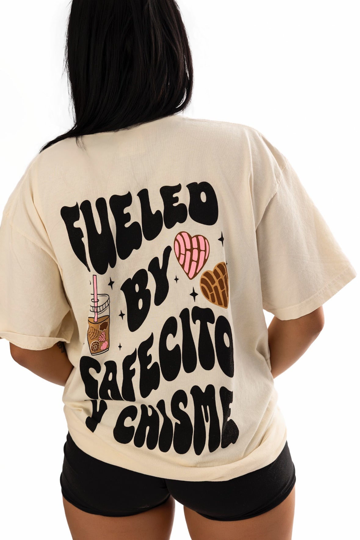 Black cotton t-shirt featuring "Fueled by Cafecito Y Chisme" graphic, from Shop Karma Tees, displayed flat on a white background.
