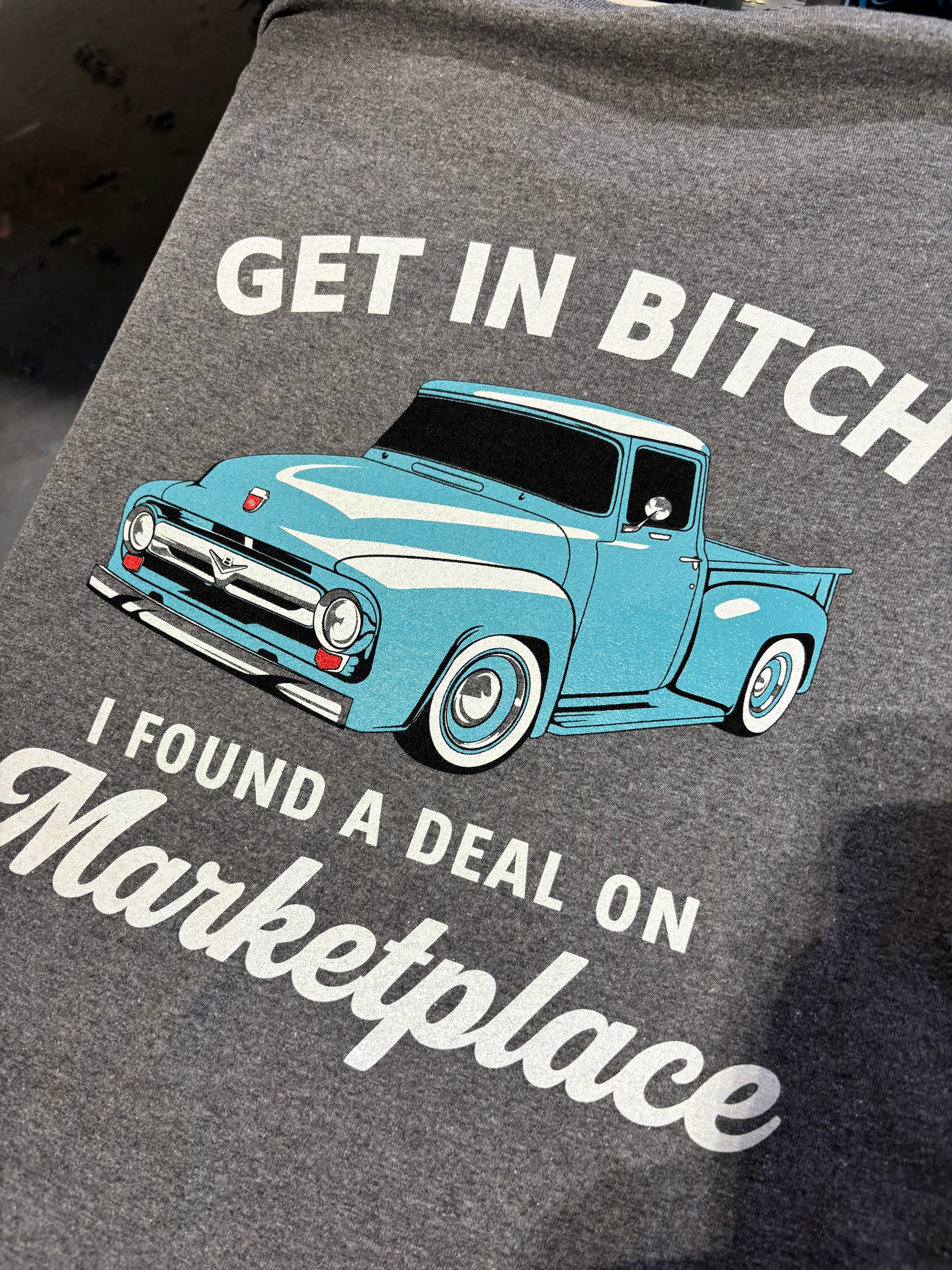 Shop Karma Tees "Get in Bitch, I found a deal on Marketplace" Ford-themed graphic t-shirt displayed on a mannequin.